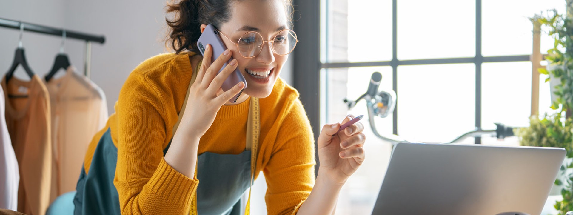 woman talking on the phone while reading from computer