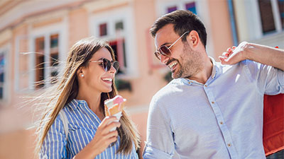 Pareja feliz de compras mientras que comen helado