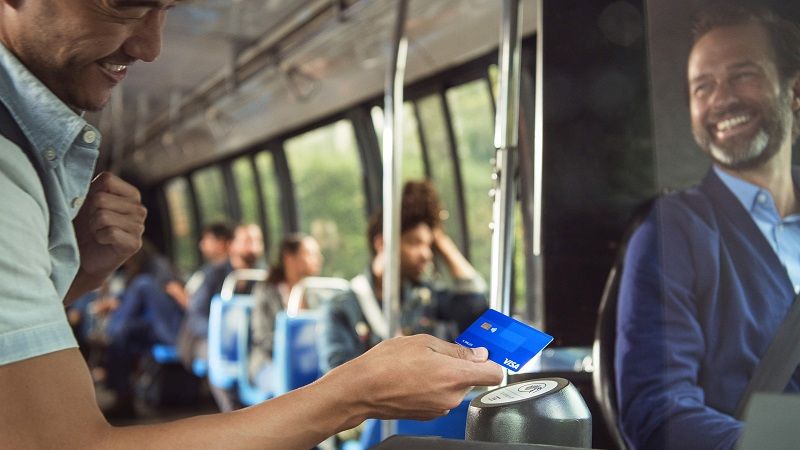 Man tapping to pay on bus with Visa card